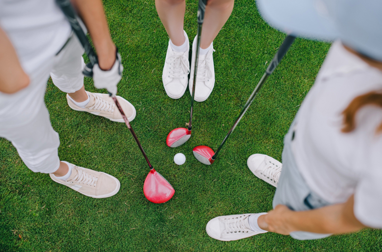 Golfers looking at golf clubs